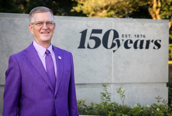 President Mark Nook standing in front of the 150 Years sign at the UNI entrance